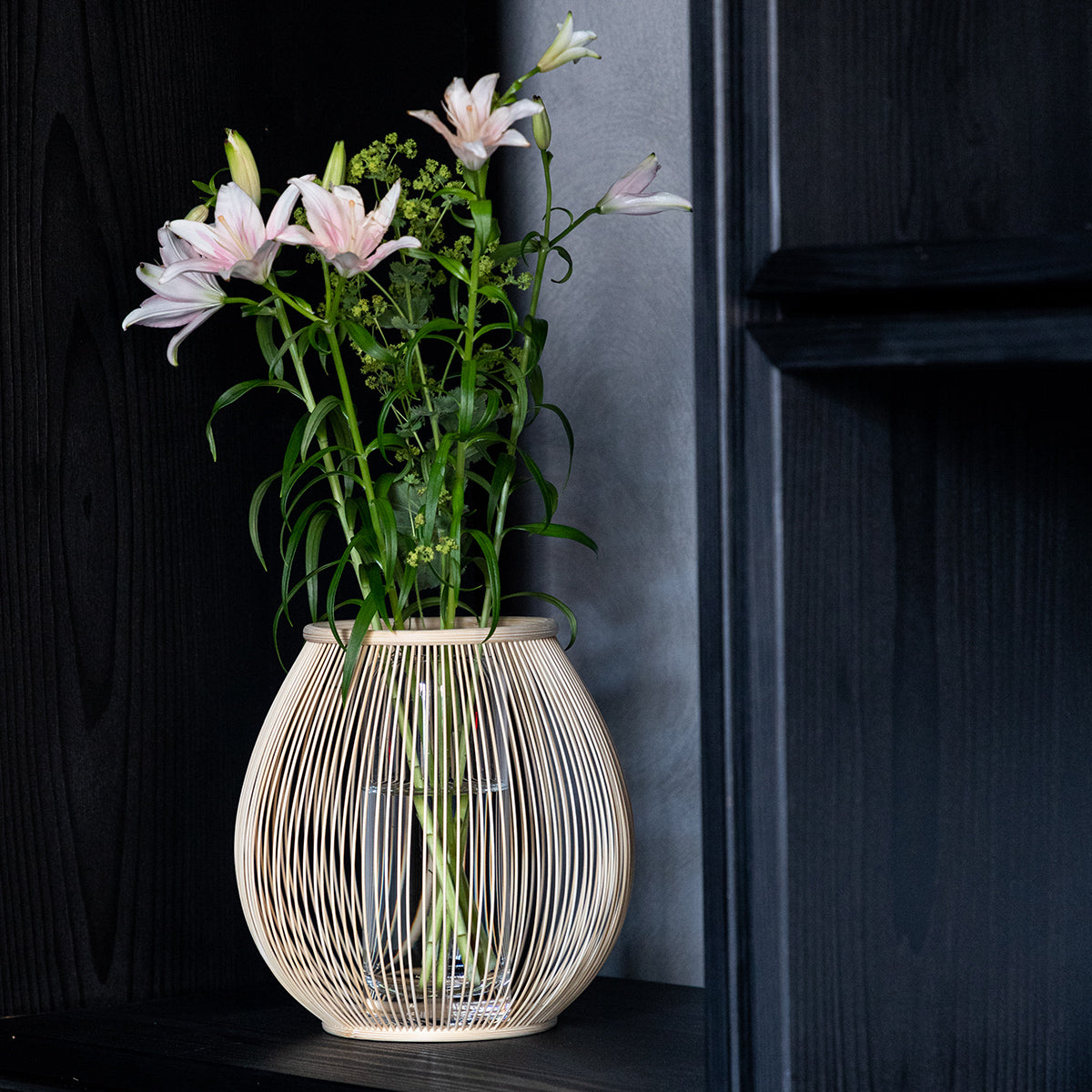 A flower vase made of beautifully curved bamboo strips